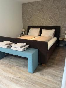 a bed with a blue bench next to it at Gastenverblijf Bladel in Bladel