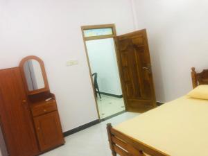 a room with a bed and a mirror and a door at Ocean waves in Trincomalee