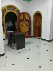 a room with two wooden doors and a table at Ocean waves in Trincomalee