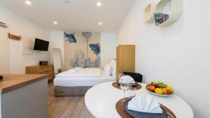 a hotel room with a bed and a table with a bowl of fruit at City Apartments in Rostock