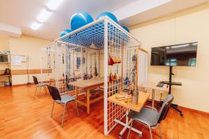 a room with a bird cage with a table and chairs at Sanatorium Dedal in Polańczyk