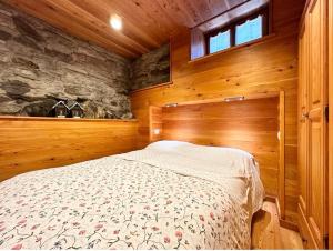 a bedroom with a bed in a wooden room at Baita Genepy - Charme Alpino in Pietra in Alagna Valsesia