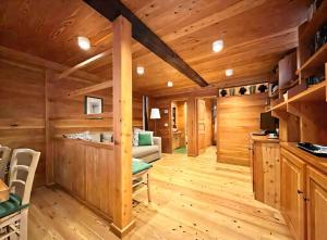 a log cabin living room with wooden walls and wooden floors at Baita Genepy - Charme Alpino in Pietra in Alagna Valsesia