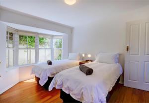 a bedroom with two beds and a window at Sunbird Cottage - Wilderness in Wilderness