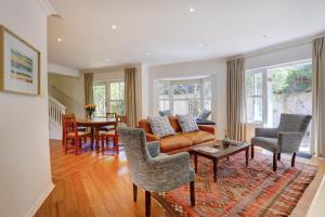 a living room with a couch and a table and chairs at Sunbird Cottage - Wilderness in Wilderness
