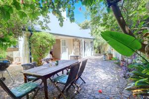a wooden table and chairs in front of a house at Sunbird Cottage - Wilderness in Wilderness
