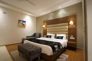 a hotel room with a large bed and a chair at RANIKOTHI BOUTiQUE HOTEL in Nagpur