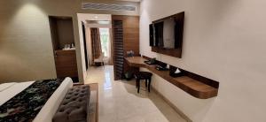 a bedroom with a bed and a tv on a wall at RANIKOTHI BOUTiQUE HOTEL in Nagpur