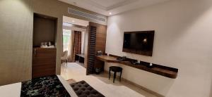a living room with a television on a wall at RANIKOTHI BOUTiQUE HOTEL in Nagpur