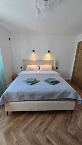 a bedroom with a bed with two towels on it at Sea Nest in Šušanj