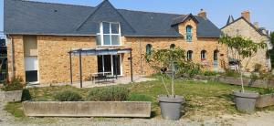 a house with two potted trees in front of it at Logis de la Provosterie CLICRO in Ahuillé