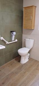 a bathroom with a white toilet and a wooden floor at Logis de la Provosterie CLICRO in Ahuillé +10 photos