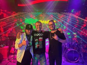 a group of three men standing in a nightclub at Happy Bear Hostel Phu Quoc in Phú Quốc