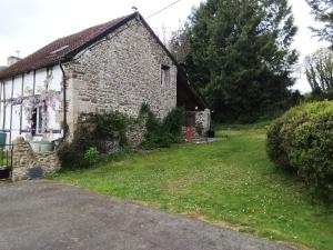 an old stone house with a green yard at The Old Cider Press in Carnoët