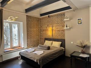 a bed in a room with a brick wall at Apart-Hotel IGORIVSKA in Kyiv +65 photos