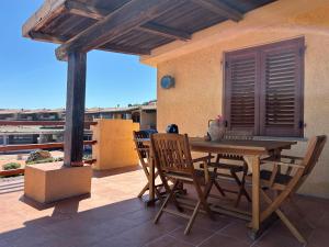a wooden table and chairs on a patio at Casa Vacanza con Piscina e Accesso diretto al Mare in Santa Marinella