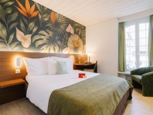 ein Hotelzimmer mit einem Bett und einem Blumenwandbild in der Unterkunft Hotel Krone Thun in Thun