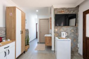a bathroom with a sink and a tv on a wall at Beach Suites İçmeler Marmaris in İçmeler