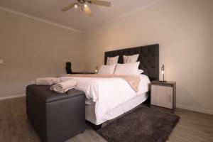 a bedroom with a large bed with a black headboard at Sandy Greens Villa in Swakopmund