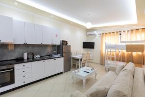 a kitchen and living room with a couch and a table at Vila Emi Apartment's in Durrës +25 photos