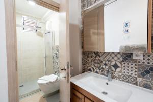 a bathroom with a sink and a toilet and a shower at Beach Suites İçmeler Marmaris in İçmeler +102 photos
