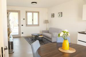 a living room with a table with a yellow vase on it at B&B Locanda Forchir in Camino al Tagliamento