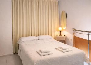 a bedroom with a bed with two towels on it at Apartamentos Larga 70 in El Puerto de Santa María