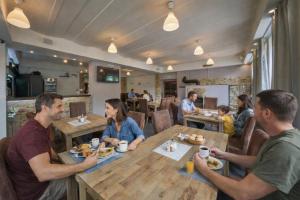 a group of people sitting at a table in a restaurant at Bouda Morava - snídaně v ceně - klidné Krkonoše in Dolni Dvur +19 photos