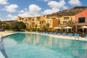 a pool at a resort with chairs and buildings at Hotel-Apartamento Las Olas in Los Cancajos