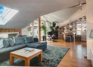 a living room with a blue couch and a table at Das Alpenhostel in Brannenburg