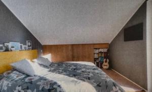 a bedroom with a bed and a guitar in it at Das Alpenhostel in Brannenburg