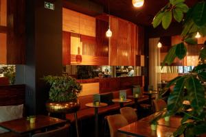 a restaurant with tables and chairs and a person in the kitchen at HotelO Kathedral in Antwerp