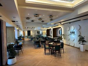 a restaurant with tables and chairs in a room at Hotel Liss in Lezhë