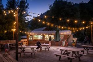 a patio with picnic tables and string lights at Huttopia Vallouise in Vallouise