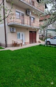 a house with a table and chairs in the yard at AMADA apartman in Vranješ