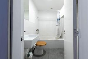a white bathroom with a toilet and a sink at Casa Atardecer in Moya