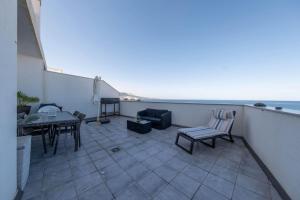 a balcony with a table and chairs and the ocean at Casa Atardecer in Moya