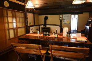 a kitchen with a bar with two wooden chairs at 古民家の宿 ふるま家 Furumaya House Gastronomic Farmstay in Deep Kyoto in Fukuchiyama +39 photos