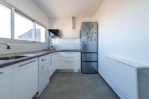 a kitchen with white cabinets and a stainless steel refrigerator at Casa Atardecer in Moya