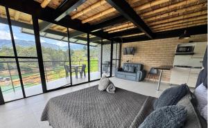 a bedroom with a bed and large glass windows at Springfield Ecoloft- Guatapé in Guatapé