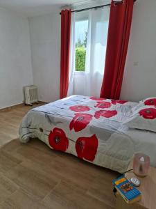 a bedroom with a bed with red flowers on it at Villa Goyavier in La Plaine des Palmistes +1 photo