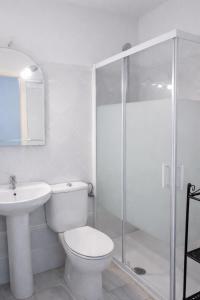 a white bathroom with a toilet and a shower at Apartamentos Larga 70 in El Puerto de Santa María +39 photos
