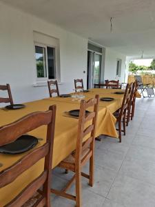 a dining room with a long table and chairs at Villa Goyavier in La Plaine des Palmistes