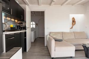 a living room with a couch and a kitchen at "El Ático Bonito"-Penthaus-Whirlpool-Atlantikblick in Las Playitas