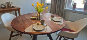 a wooden table with a vase of yellow flowers on it at Spoor 24 in Dieren