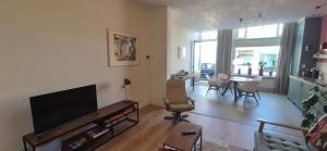 a living room with a television and a table and chairs at Spoor 24 in Dieren