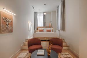 a bedroom with a bed and two chairs and a table at Leon by Zoia Living in Piraeus
