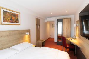 a hotel room with a bed and a desk at Mariaweiler Hof in Düren - Eifel +77 photos