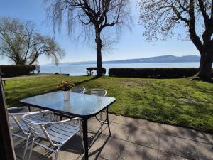 a table and chairs with a view of the water at La Bordu in Grandson