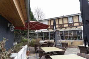 a patio with tables and chairs and an umbrella at Petit Wannsee GmbH in Berlin